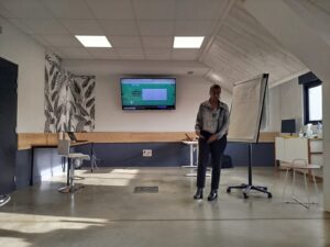 présentation d'une formation Inclusiel, Sarah Hammou debout devant un écran avec le contenu de la formation