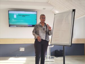 présentation d'une formation Inclusiel, Sarah Hammou debout devant un écran avec le contenu de la formation