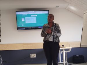 présentation d'une formation Inclusiel, Sarah Hammou debout devant un écran avec le contenu de la formation